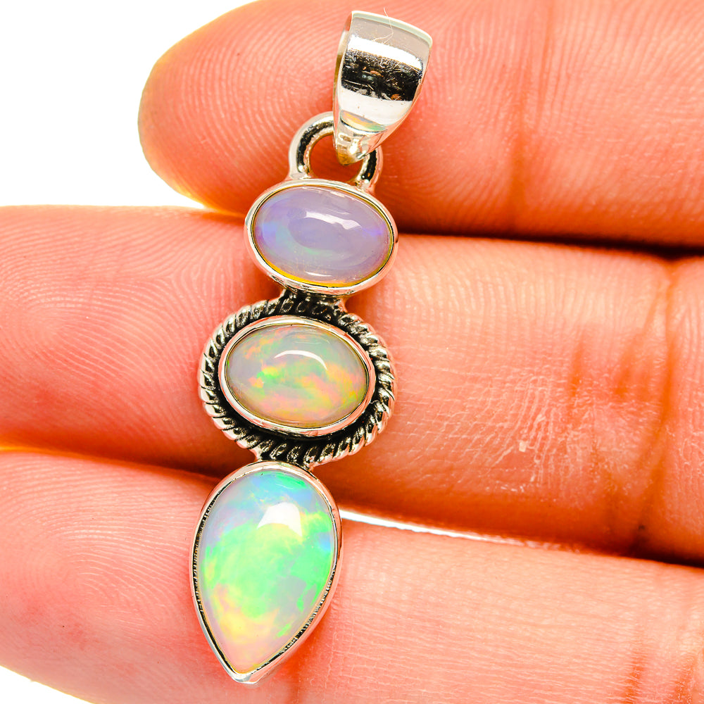 Close-up sterling silver opal pendant with three iridescent oval stones on bail