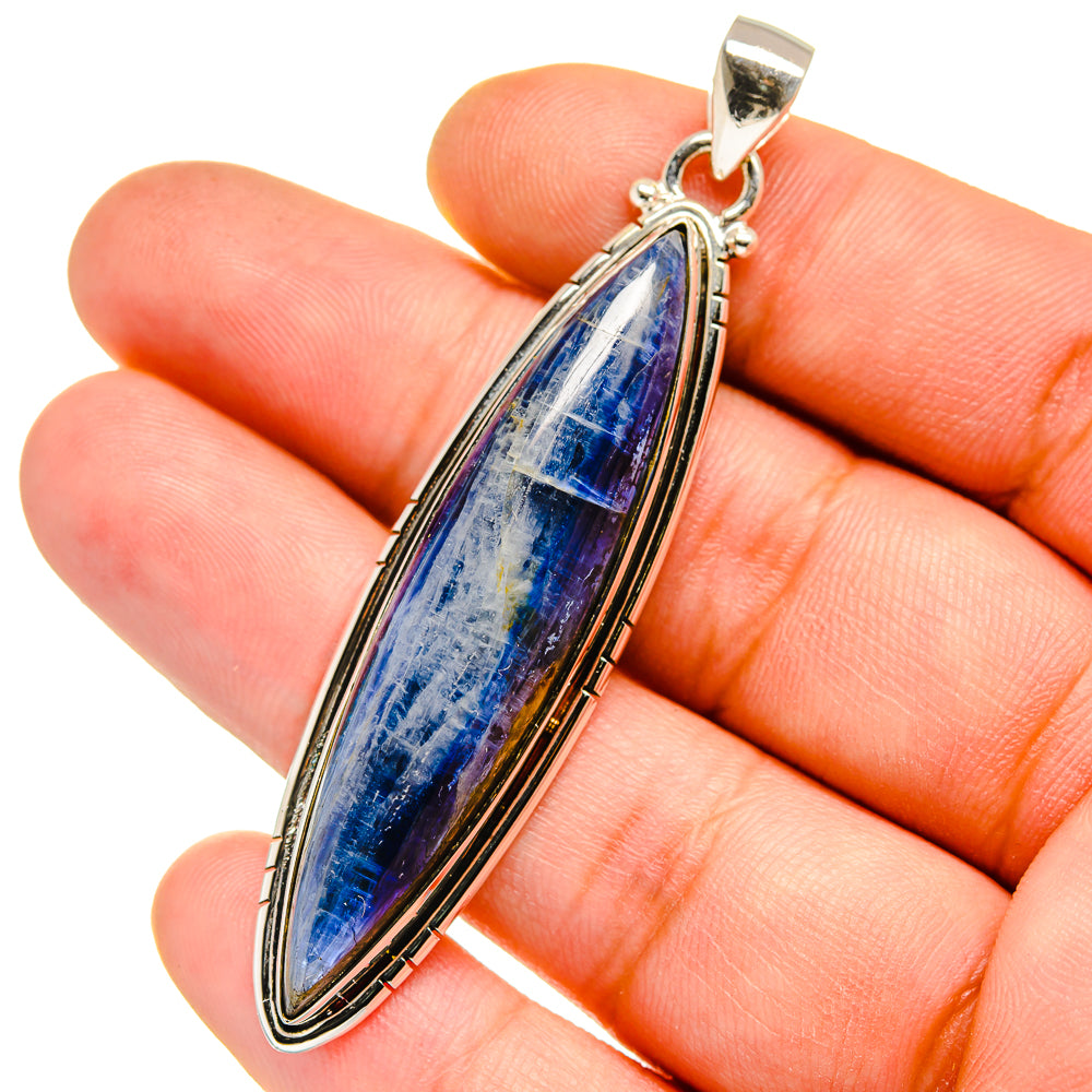 Sterling silver kyanite pendant close-up on hand, blue oval teardrop cabochon