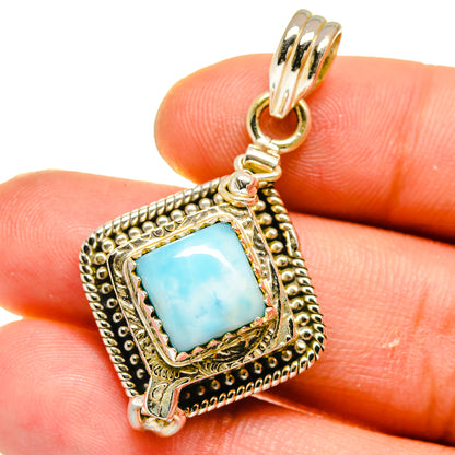 Ornate sterling silver Larimar pendant with blue gemstone center and hanging bail.