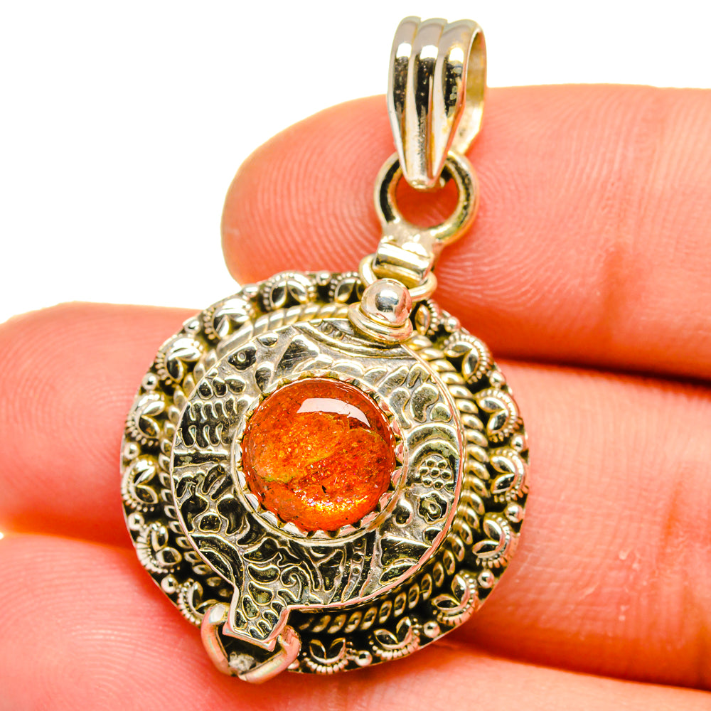 Gold-tone 925 sterling silver round poison pendant with orange sunstone center
