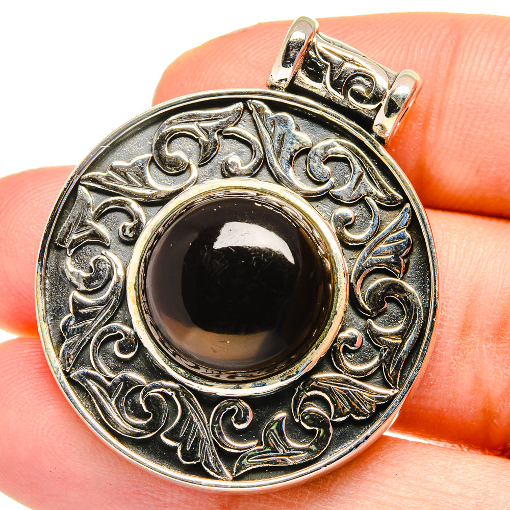 Smoky quartz pendant in sterling silver with ornate circular filigree and dark cabochon