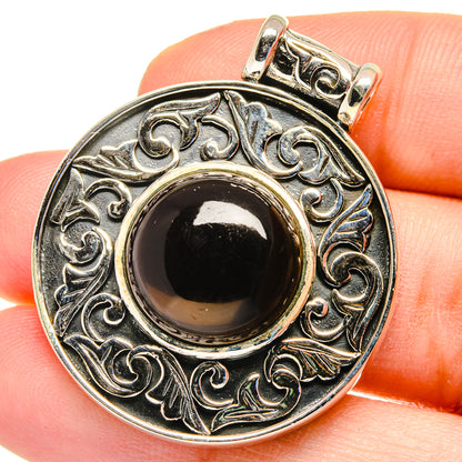 Smoky quartz pendant in sterling silver with ornate circular filigree and dark cabochon