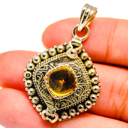 Sterling silver citrine pendant close-up with ornate filigree bezel and amber stone