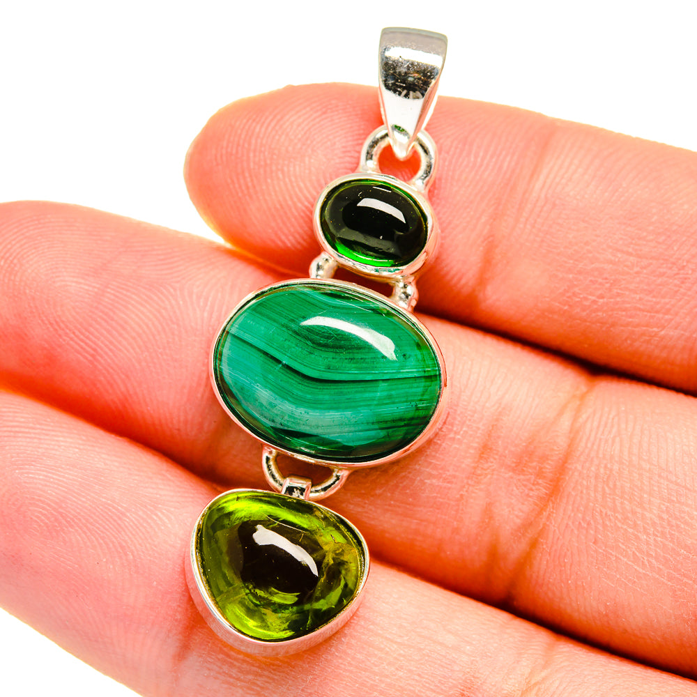 Green oval and heart gemstone pendant with sterling silver bail, close-up on hand
