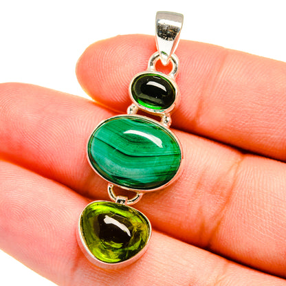 Green oval and heart gemstone pendant with sterling silver bail, close-up on hand