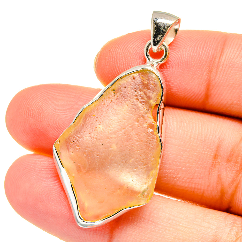925 sterling silver pendant with irregular desert glass, peach-pink teardrop on hand