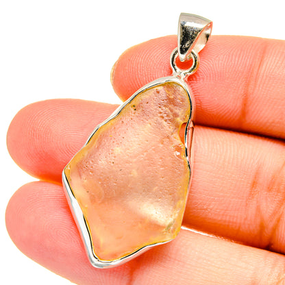 925 sterling silver pendant with irregular desert glass, peach-pink teardrop on hand