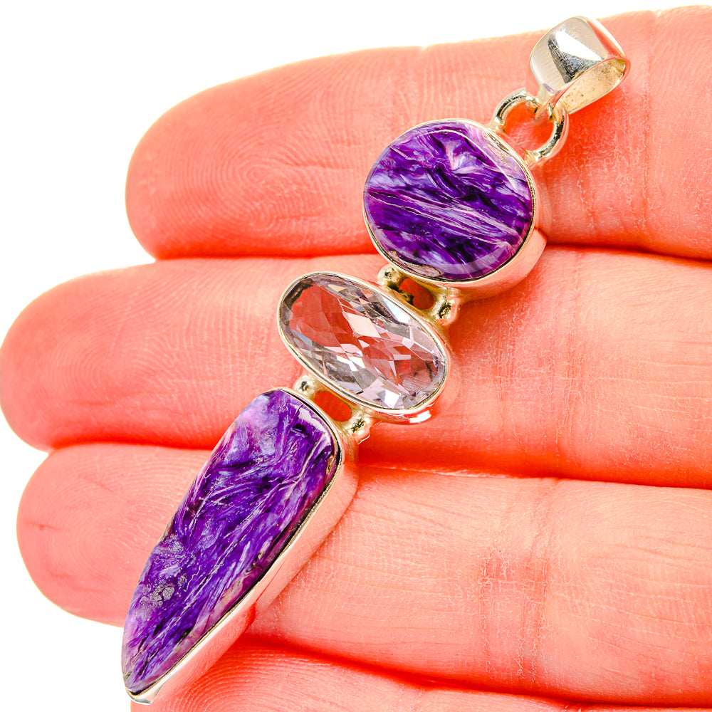 Purple gemstone pendant close-up on finger, oval and oval-cut stones, gold-tone bail