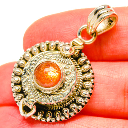 Orange sunstone cabochon pendant in ornate 925 sterling silver bezel, gold-tone bail
