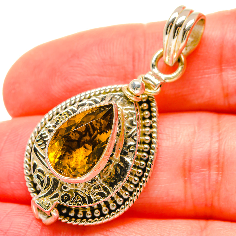 Citrine teardrop pendant detail with textured silver halo and clasped bail loop