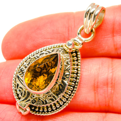 Citrine teardrop pendant detail with textured silver halo and clasped bail loop