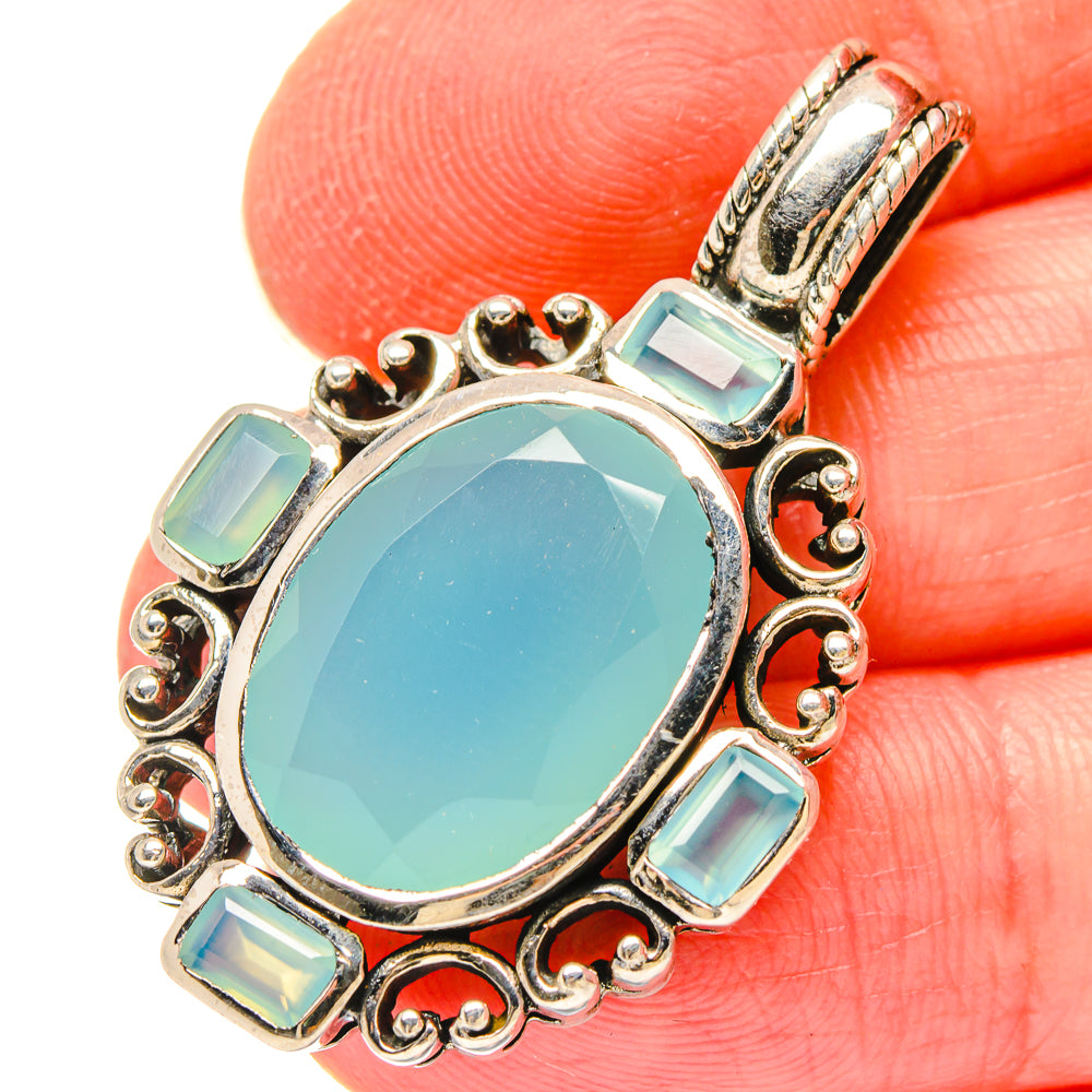 Oval aqua chalcedony pendant in 925 sterling silver with gemstone frame and bail.
