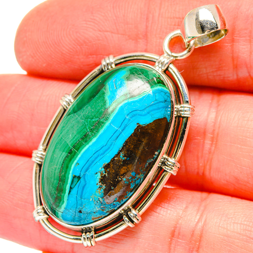 Sterling silver oval pendant close-up with green and blue stone, arched frame and top bail.