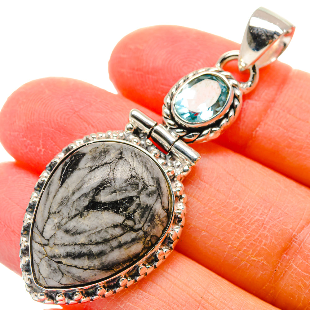 Oval gray pinolith jasper pendant with round blue topaz, ornate sterling silver setting