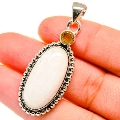 Oval white stone pendant with round yellow citrine accent in silver bezel setting