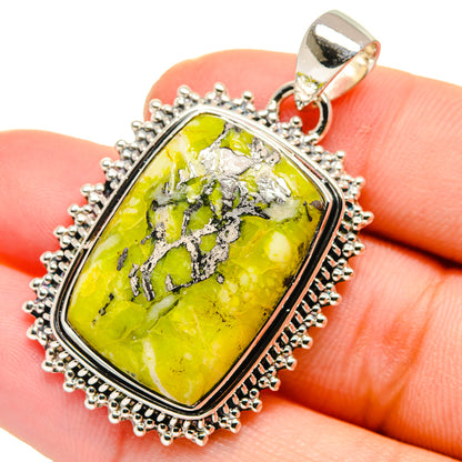 Silver pendant with rectangular green opal, black veins, and beaded halo edge