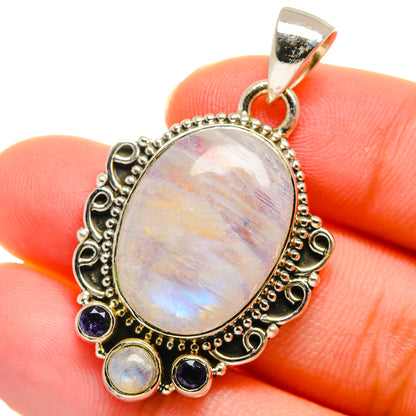 Oval rainbow moonstone pendant with silver filigree border and round blue gemstones