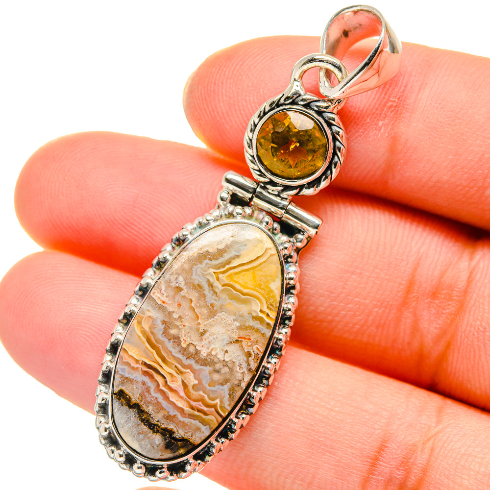 Oval citrine and lace agate pendant with ornate silver bezels and bail.