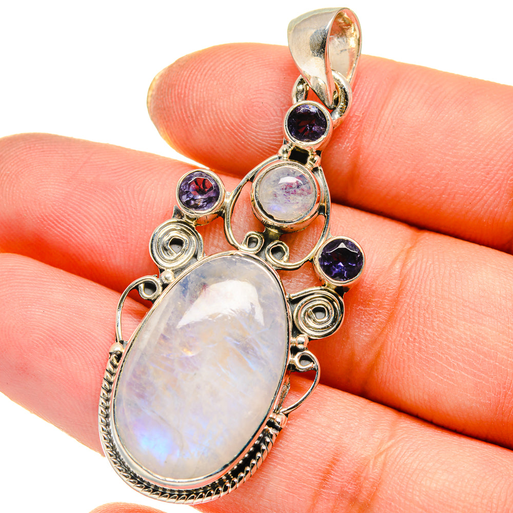 Sterling silver moonstone pendant on hand, oval opal-like stone with dark blue accents