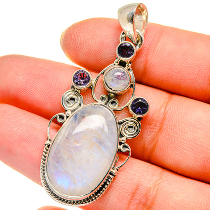 Sterling silver moonstone pendant on hand, oval opal-like stone with dark blue accents