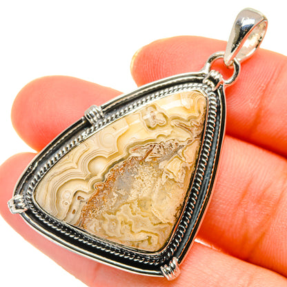 Triangular sterling silver agate pendant with yellow-brown stone and top loop bail.