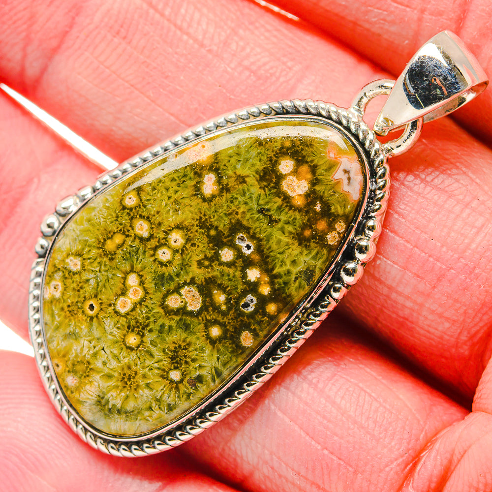Ocean jasper teardrop pendant in silver-tone frame, green and yellow speckled stone.