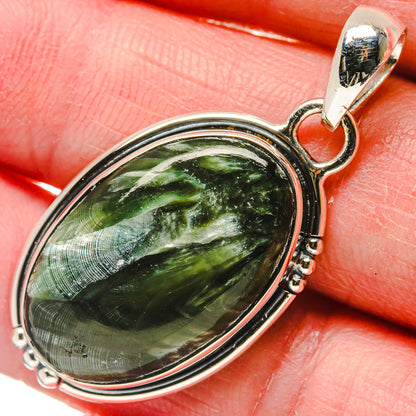 Close-up oval green seraphinite pendant with polished 925 sterling silver bail