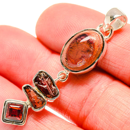 Sterling silver pendant with oval orange fire opal and red square garnet accents