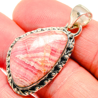 Pink rhodochrosite teardrop pendant close-up, silver bail and textured bezel
