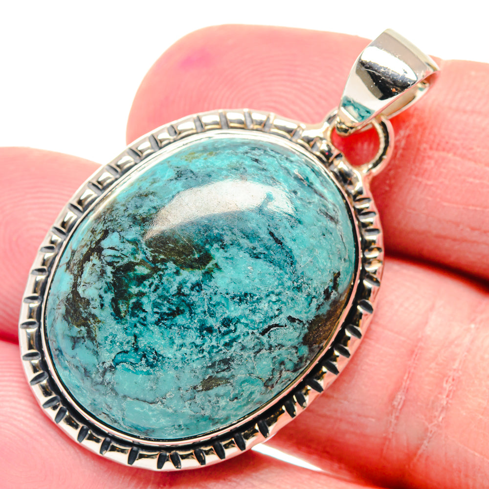 Oval turquoise pendant with etched silver bezel and bail, angled close-up