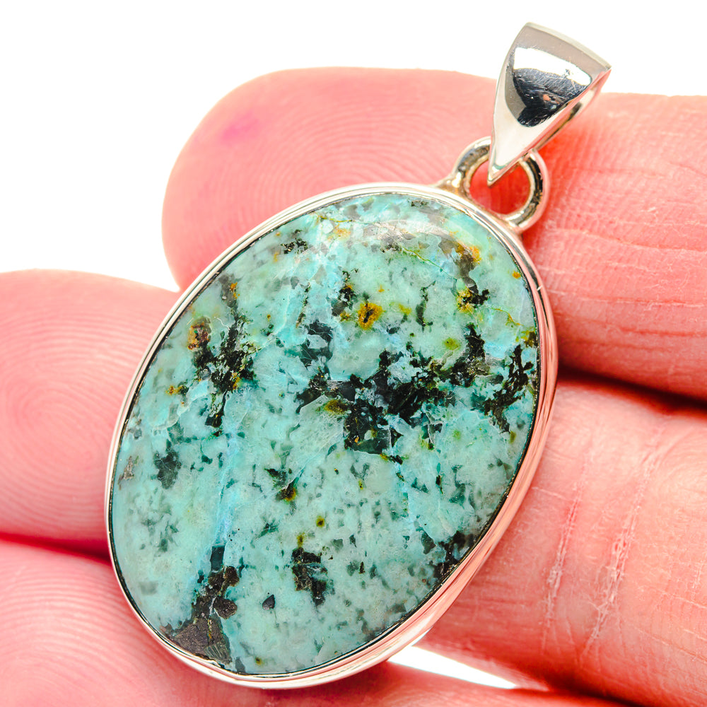 Oval turquoise pendant with mottled turquoise-and-black stone in polished 925 silver bezel