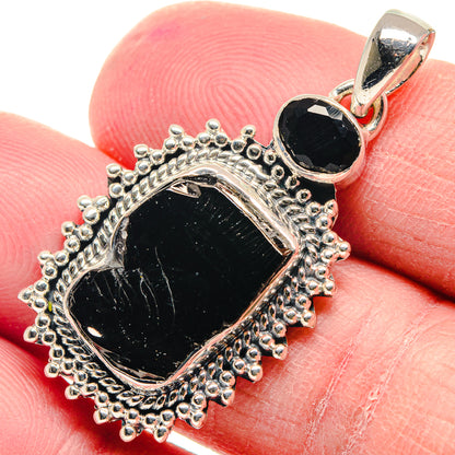 Black rough stone pendant in ornate silver halo setting with loop bail
