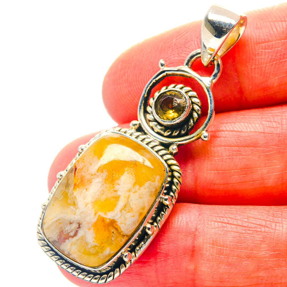 Close-up oval citrine cabochon pendant with ornate silver bail and bezel, yellow-gold stone