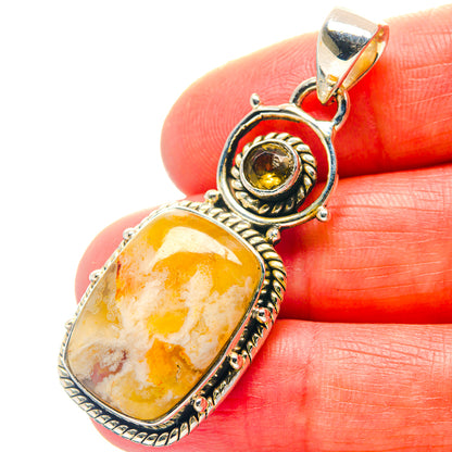 Close-up oval citrine cabochon pendant with ornate silver bail and bezel, yellow-gold stone