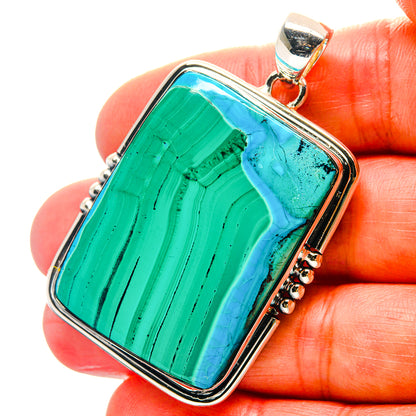 Rectangular green-blue chrysocolla pendant on beaded silver edge, held in hand