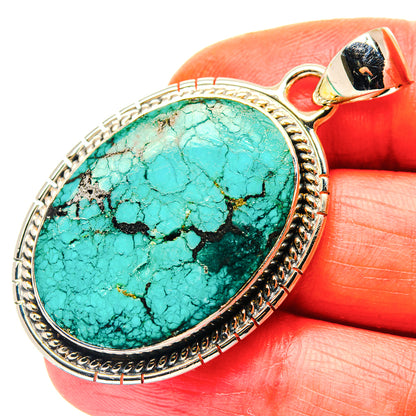 Sterling silver pendant with oval turquoise cabochon and decorated bail