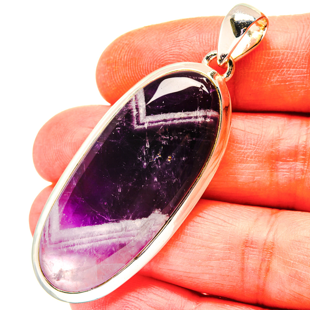 Sterling silver amethyst pendant with dark purple elongated oval stone and bail loop.