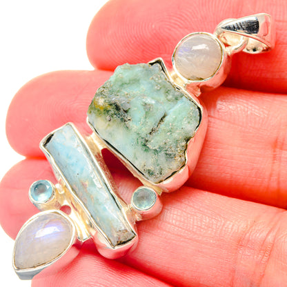 Sterling silver pendant close-up: rough green stone with light blue bar and moonstone discs