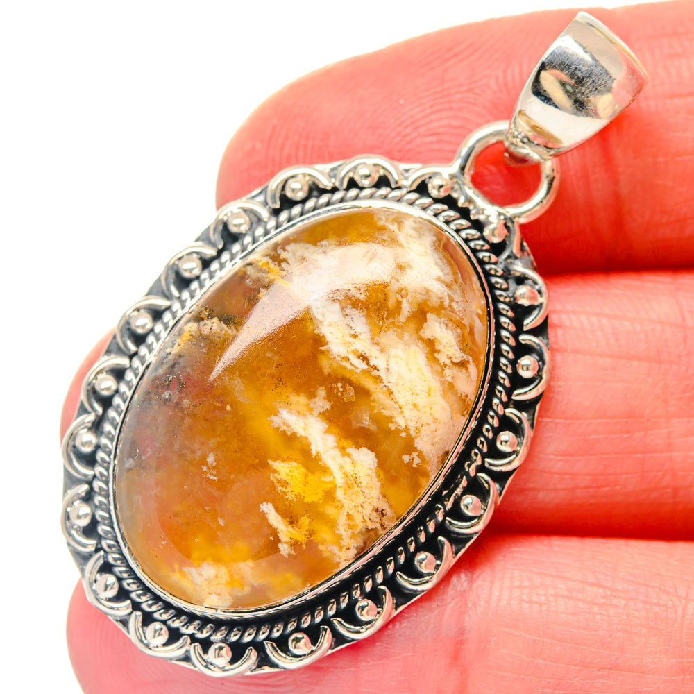 Sterling silver oval agate pendant with ornate bezel and gold-orange marbled stone