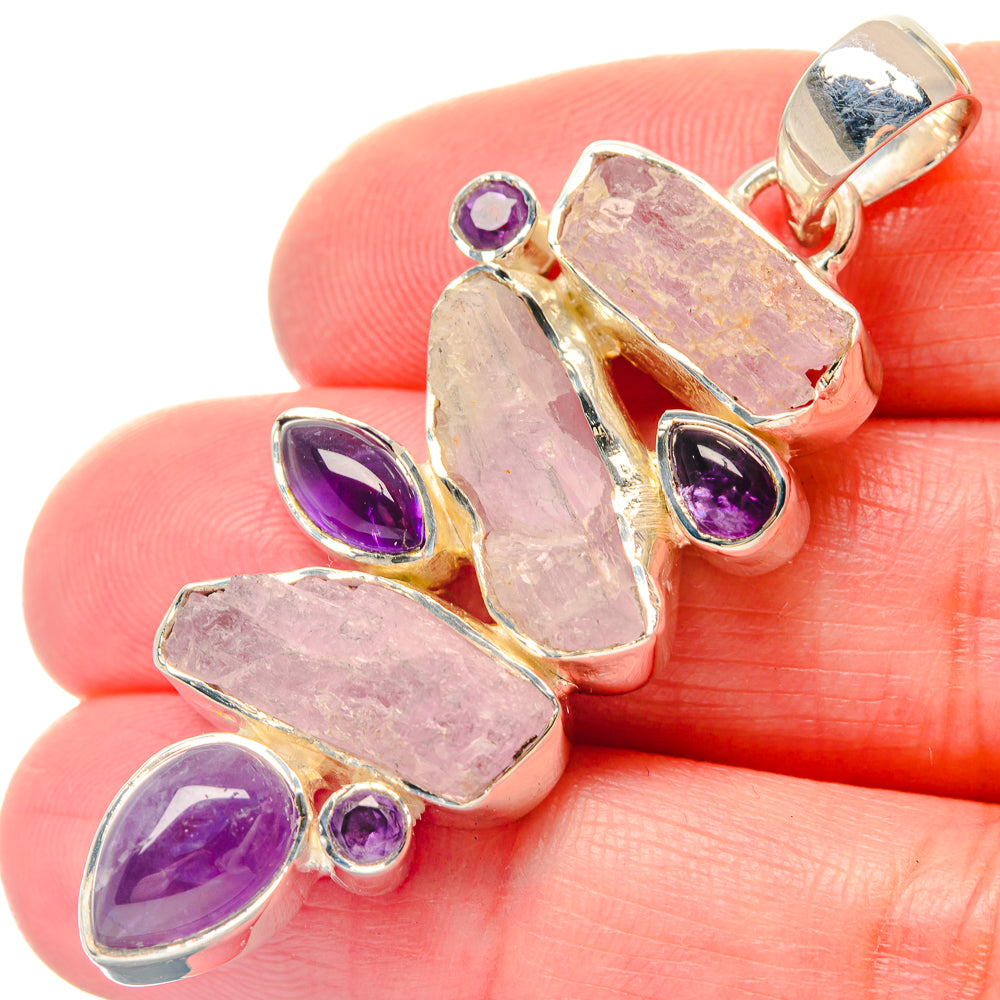 Close-up rough rose quartz pendant with amethyst stones and 925 silver bail on hand