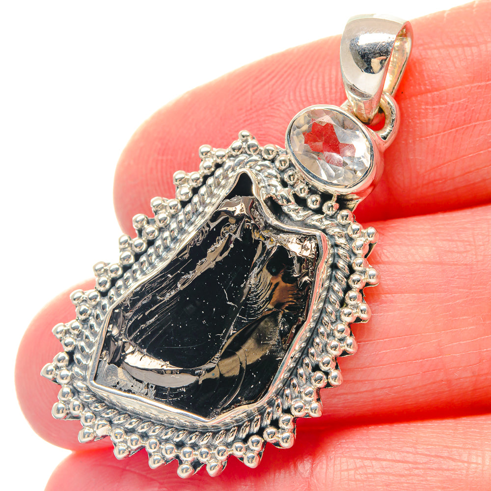 Silver pendant with rough dark stone teardrop and clear round gemstone bail