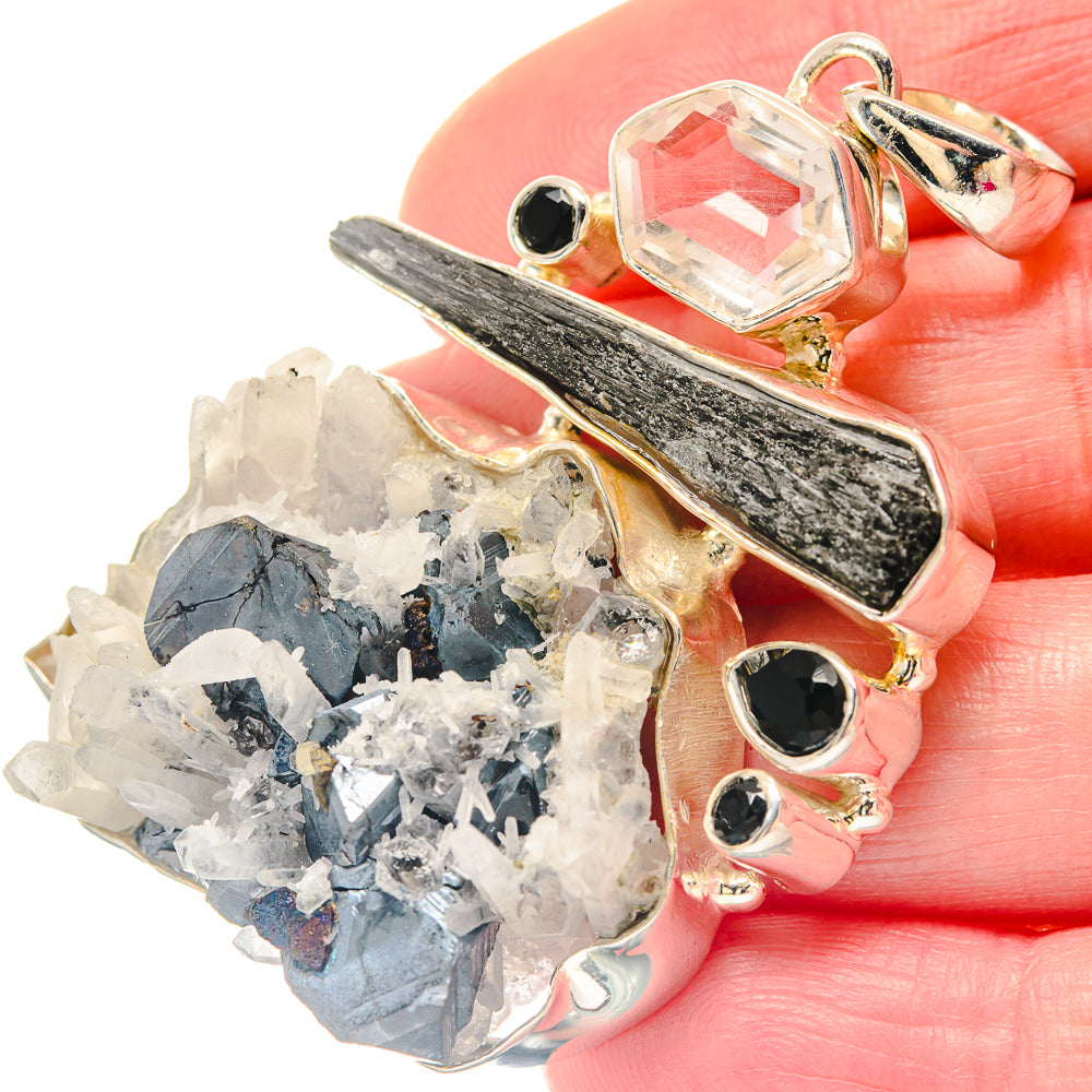Gold-tone pendant with black onyx stones, faceted clear quartz, and white-blue crystal cluster