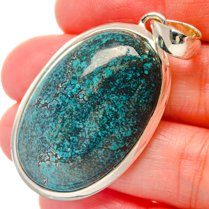Oval turquoise gemstone pendant in silver-tone bezel with round bail, close-up view