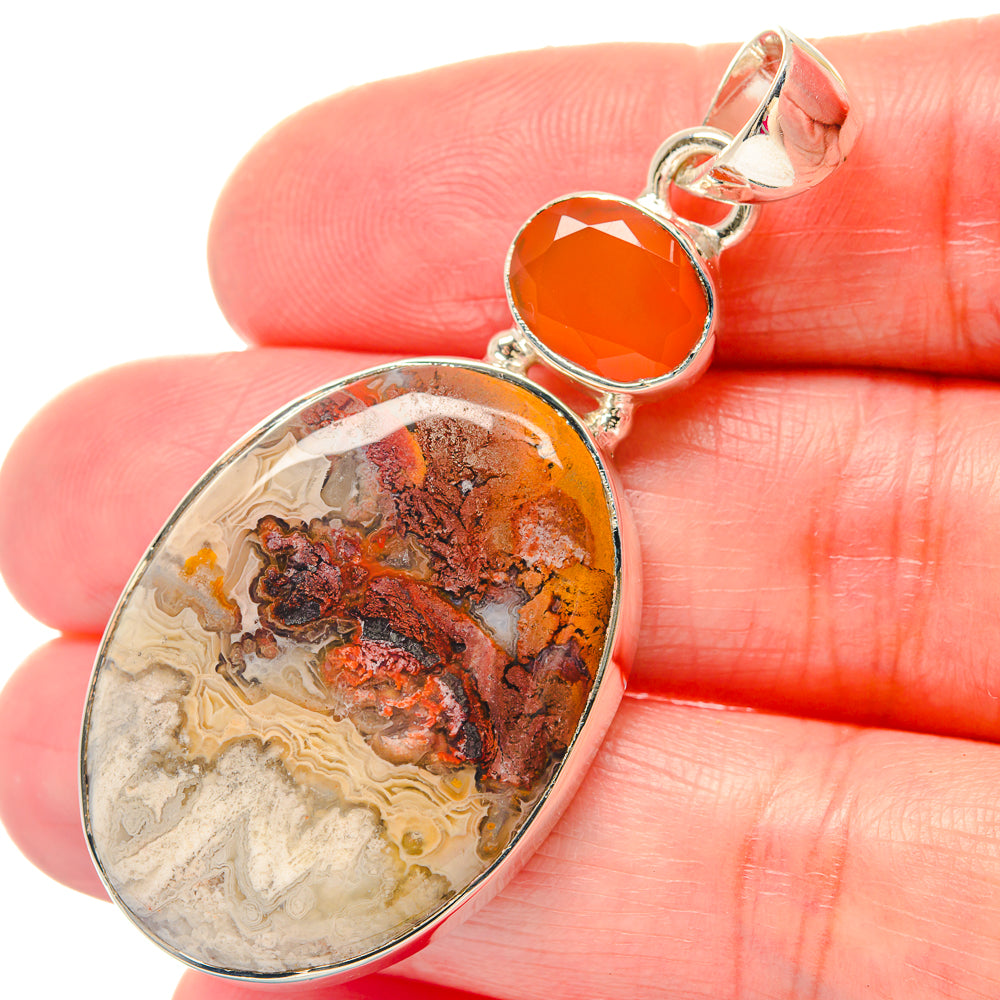 Oval crazy lace agate and orange carnelian 925 silver pendant, close-up on hand