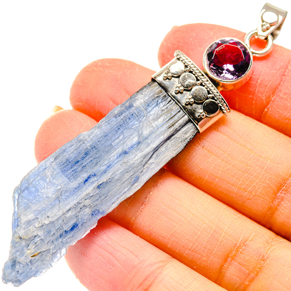 Rough blue crystal pendant with faceted purple-red gemstone in ornate 925 silver setting