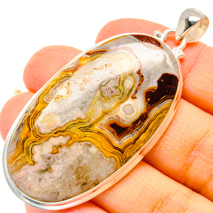 Oval lace agate pendant with orange, cream and dark banding in sterling silver setting