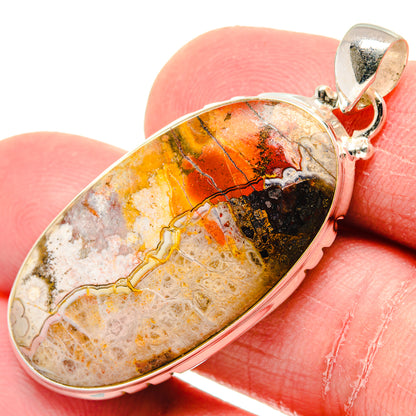 Crazy lace agate pendant, oval stone with orange, black, white patterns in silver setting
