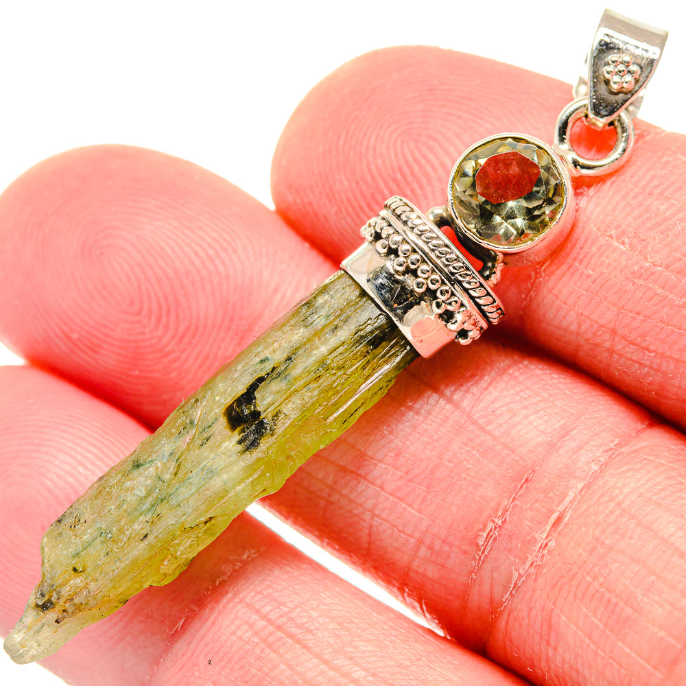 Sterling silver pendant with rough green peridot crystal, round red stone, and bail