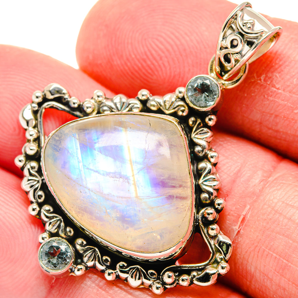 Teardrop moonstone pendant with round blue topaz stones and decorative 925 silver border