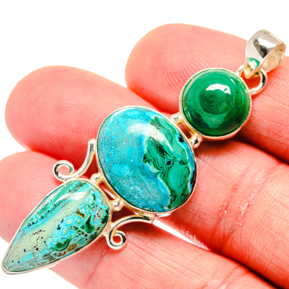 Gold-tone stone pendant with turquoise oval and green round beads on finger